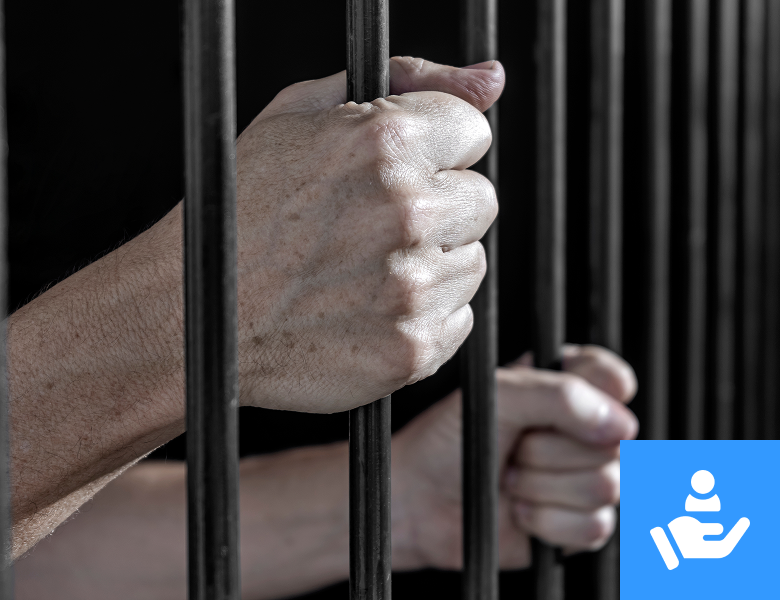 Hands gripping prison cell bars tightly.